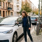 Frau schließt mit dem Smartphone ein Carsharing-Auto auf einer Straße in der Stadt auf